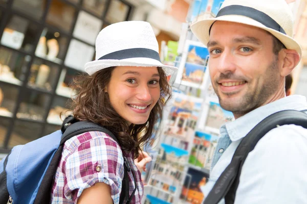 Jonge gelukkige paar ansichtkaarten kiezen tijdens de vakantie — Stockfoto