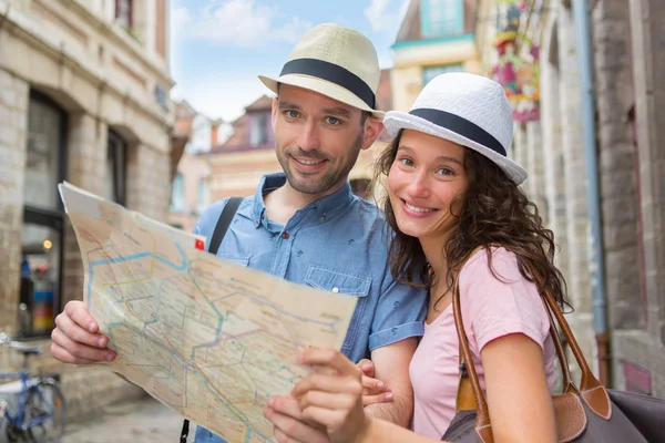 Couple of young attractive tourists watching map — Stock Photo, Image