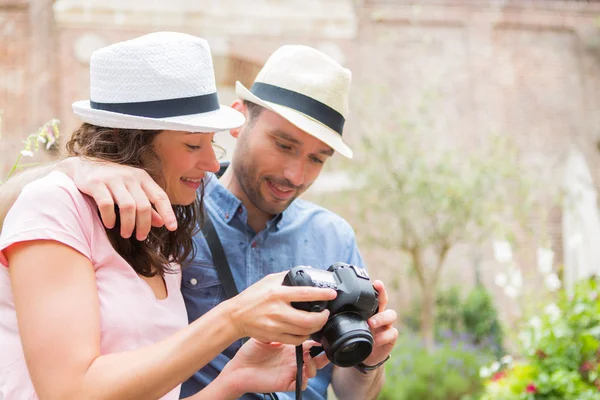 Pareja joven de turistas viendo fotografías — Foto de Stock