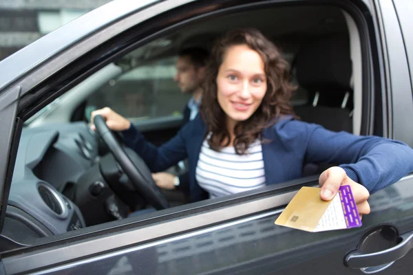 Couple in his car paying at a toll booth — Stock Photo, Image