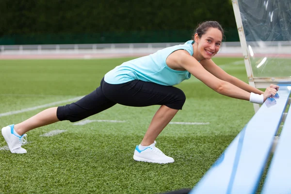 Ung attraktiv kvinna stretching hennes ben — Stockfoto