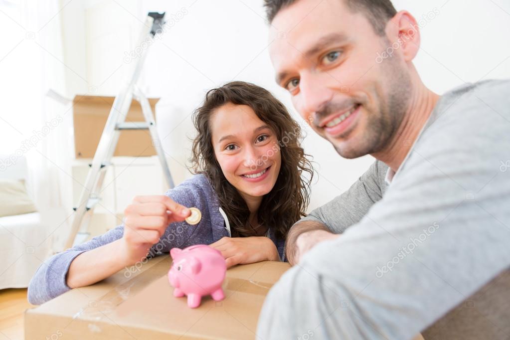 Young couple saving money in a piggy bank