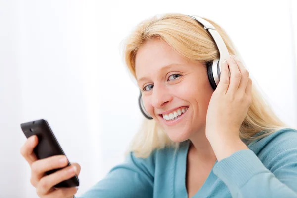Portret van een jonge aantrekkelijke vrouw listenning muziek — Stockfoto