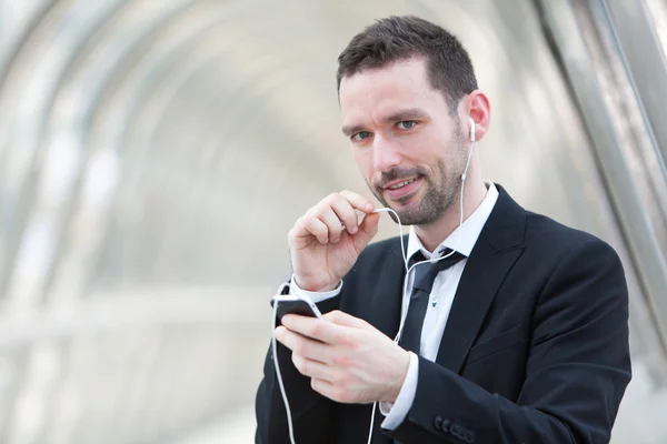 Portret van een aantrekkelijke zakenman met behulp van handsfree set — Stockfoto