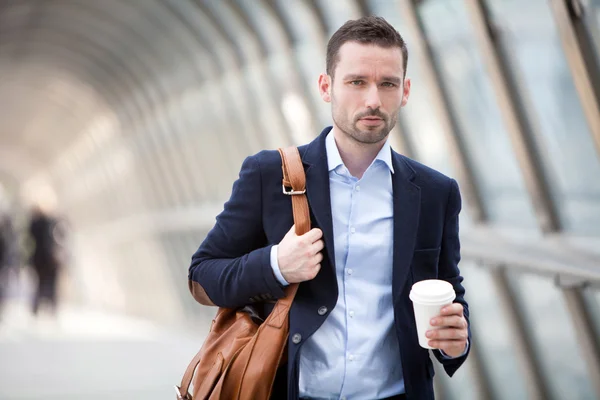 Young attractive man drinking coffee on his way — Stock Photo, Image