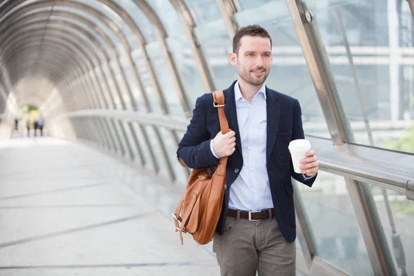 Young attractive man drinking coffee on his way — Stock Photo, Image