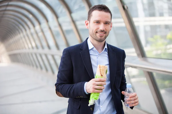 Young attractive man eating fast his lunch — Stock Photo, Image