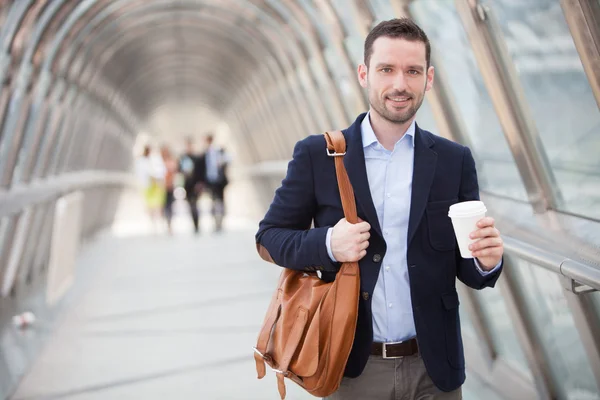 Joven hombre atractivo bebiendo café en su camino —  Fotos de Stock
