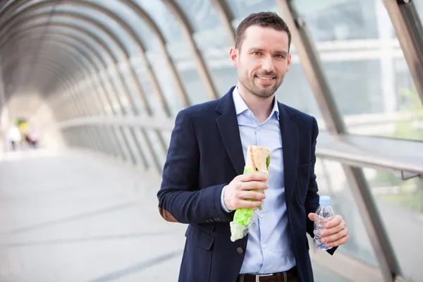 Young attractive man drinking coffee on his way — Stock Photo, Image