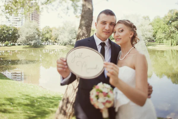 Panna młoda i pan młody ze znakiem "just married" — Zdjęcie stockowe