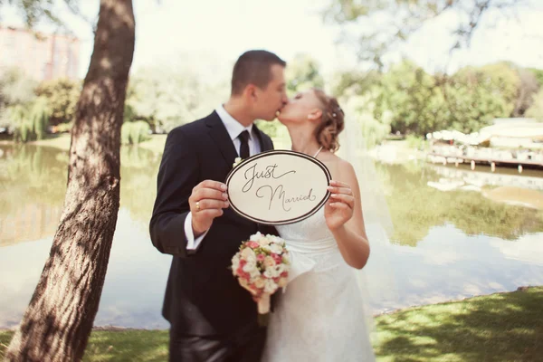 Noiva e noivo com um sinal "Apenas casado " — Fotografia de Stock