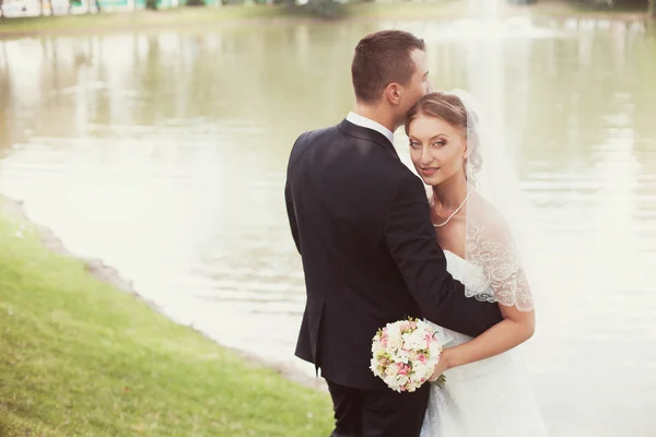 Sposo e sposo in parco vicino al lago — Foto Stock