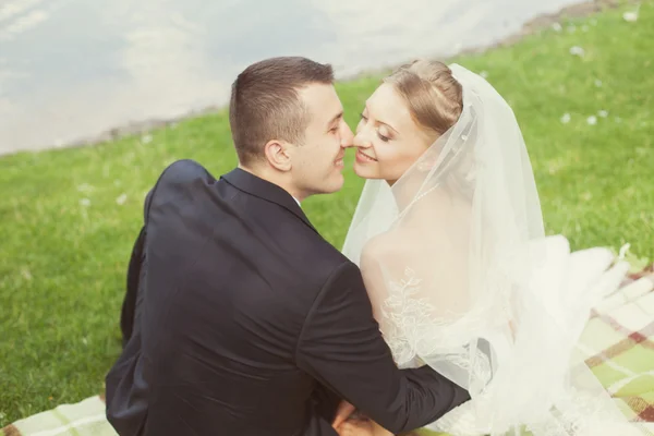Nevěsta a ženich v parku u jezera — Stock fotografie