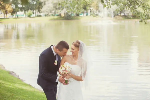 Novia y novio en el parque cerca del lago — Foto de Stock