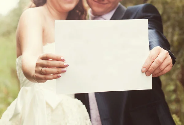 Bride and groom with blank of paper — Stock Photo, Image