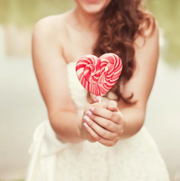 Bride  with candy in the form of heart — Stock Photo, Image