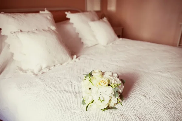 Wedding bouquet on a bed — Stock Photo, Image