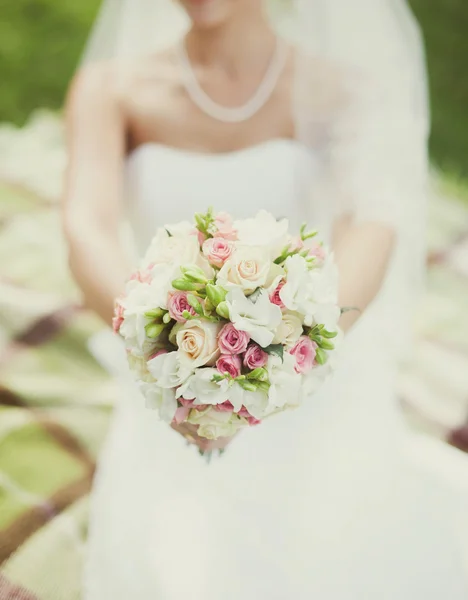 Novia en un vestido blanco con un ramo — Foto de Stock