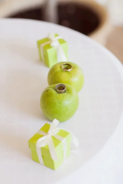 Anéis de casamento e maçãs verdes Imagem De Stock
