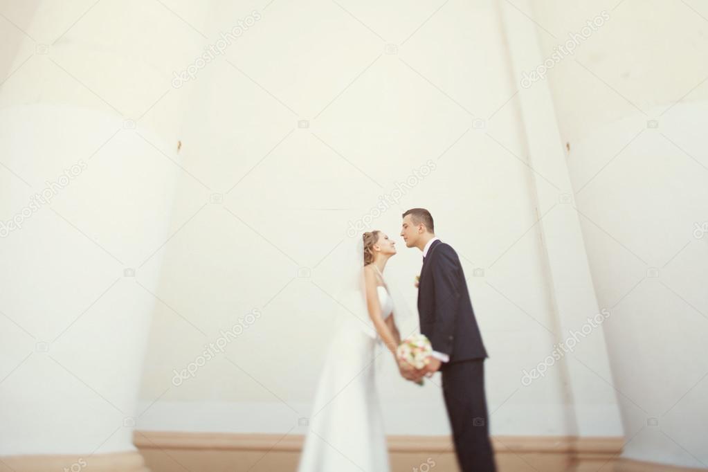 Bride and groom  posing near the white columns