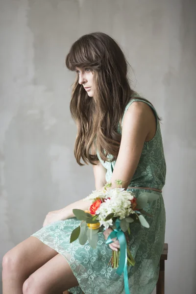 Bela menina morena com um buquê de flores — Fotografia de Stock