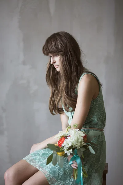 Bela menina morena com um buquê de flores — Fotografia de Stock