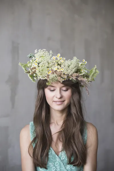 Beautiful brunette girl with a wreath in her hair — Stock Photo, Image