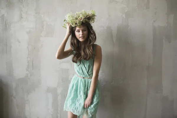 Beautiful brunette girl with a wreath in her hair — Stock Photo, Image