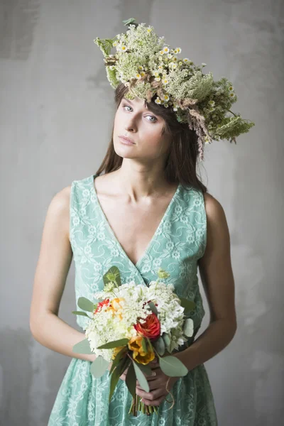 Belle fille, brune avec un bouquet de fleurs et une couronne — Photo