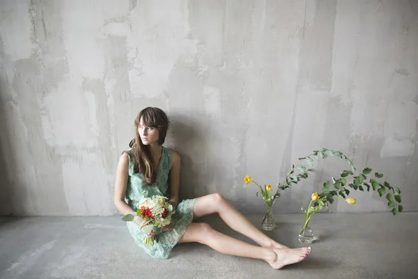 Vacker brunett tjej med en bukett blommor — Stockfoto