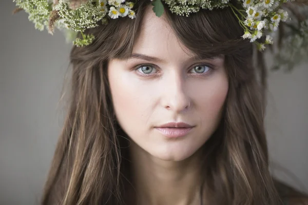 Beautiful brunette girl with a wreath in her hair — Stock Photo, Image