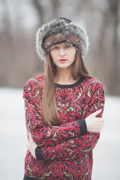 Hermosa chica en el parque en invierno, en un sombrero de piel — Foto de Stock