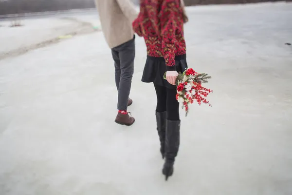 Femme et homme dans le parc en hiver avec un bouquet de fleurs rouges — Photo