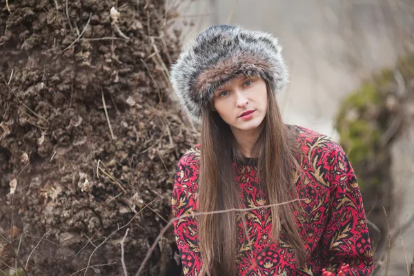 Vacker flicka i parken i vinter, i en pälsmössa — Stockfoto