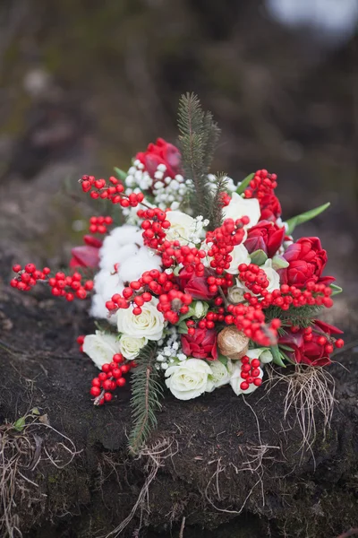 Winter wedding bouquet with pine cones and red and white flowers — Stock Photo, Image