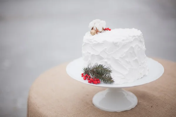 Vit bröllopstårta med en kvist av Gran och röda bär — Stockfoto