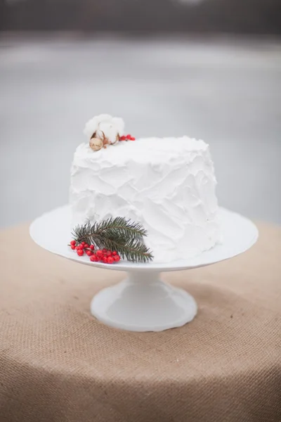 Vit bröllopstårta med en kvist av Gran och röda bär — Stockfoto
