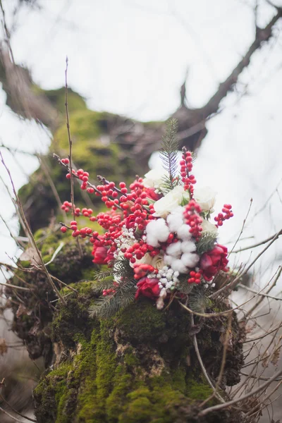 Ramo de boda de invierno con conos de pino y flores rojas y blancas Imagen De Stock