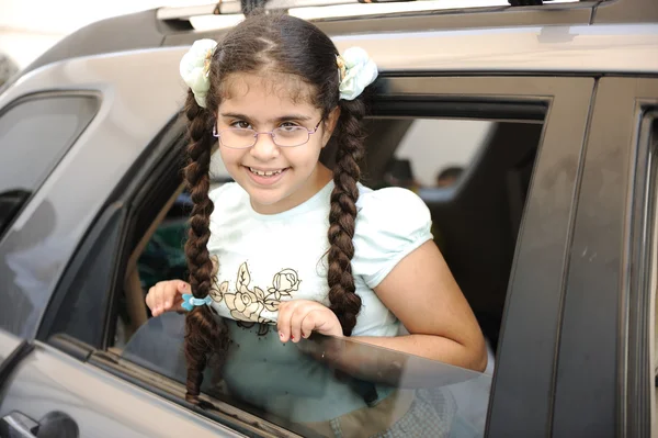 Το μικρό χαριτωμένο κορίτσι ιππασία ένα αυτοκίνητο και να ψάχνει μέσα από το παράθυρο — Φωτογραφία Αρχείου