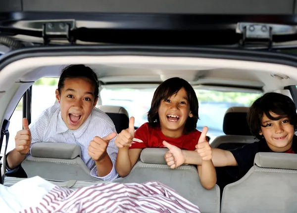 Smiling happy children in car with thumb up — Stock Photo, Image