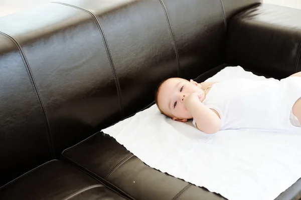 Baby on leather sofa — Stock Photo, Image