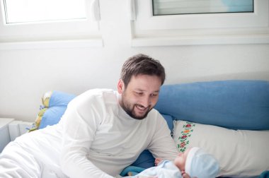 Mutlu ve sevgi dolu bir baba ve kucağında yeni doğmuş bir bebek.