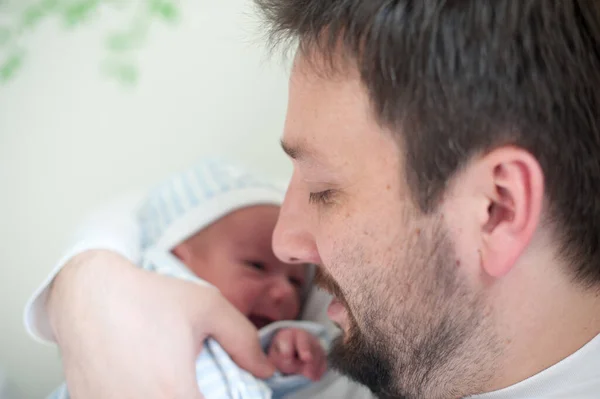 Hombre como un padre feliz y amoroso con el bebé recién nacido en los brazos — Foto de Stock