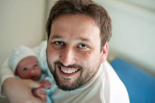 Homem como um pai feliz e amoroso com bebê recém-nascido nos braços — Fotografia de Stock