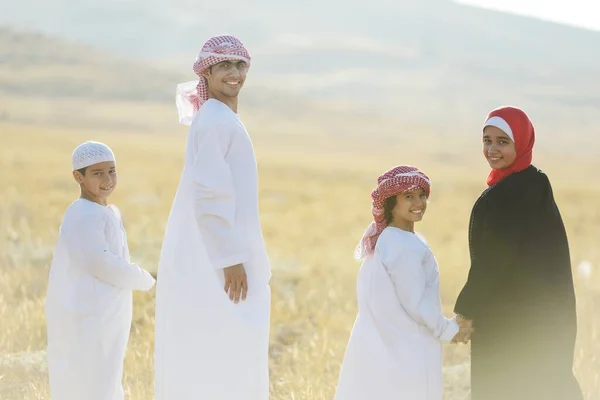Família árabe na natureza à espera do pôr do sol — Fotografia de Stock
