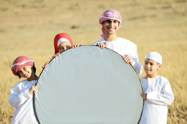 Arabic family in nature holding copy space banner — Stock Photo, Image