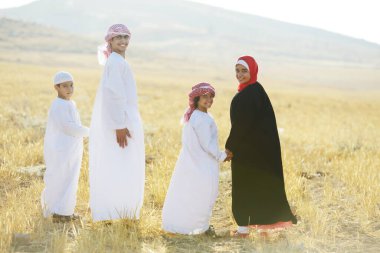 Doğada gün batımını bekleyen Arap ailesi