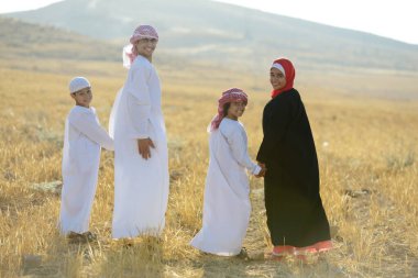 Doğada gün batımını bekleyen Arap ailesi