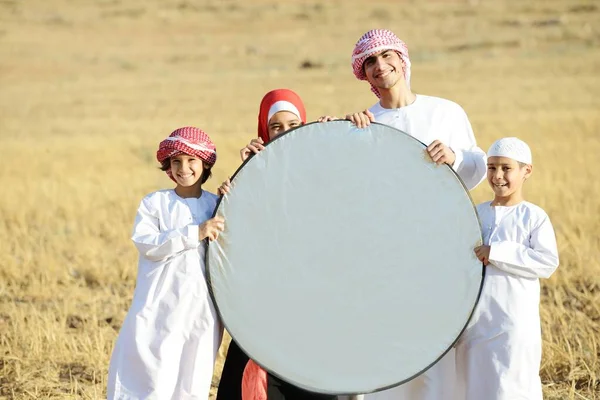 Familia árabe en la naturaleza sosteniendo banner espacio de copia — Foto de Stock