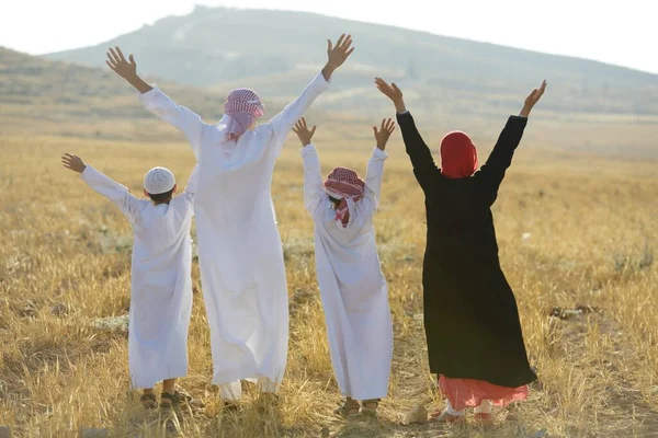 Familia árabe en la naturaleza esperando la puesta del sol — Foto de Stock